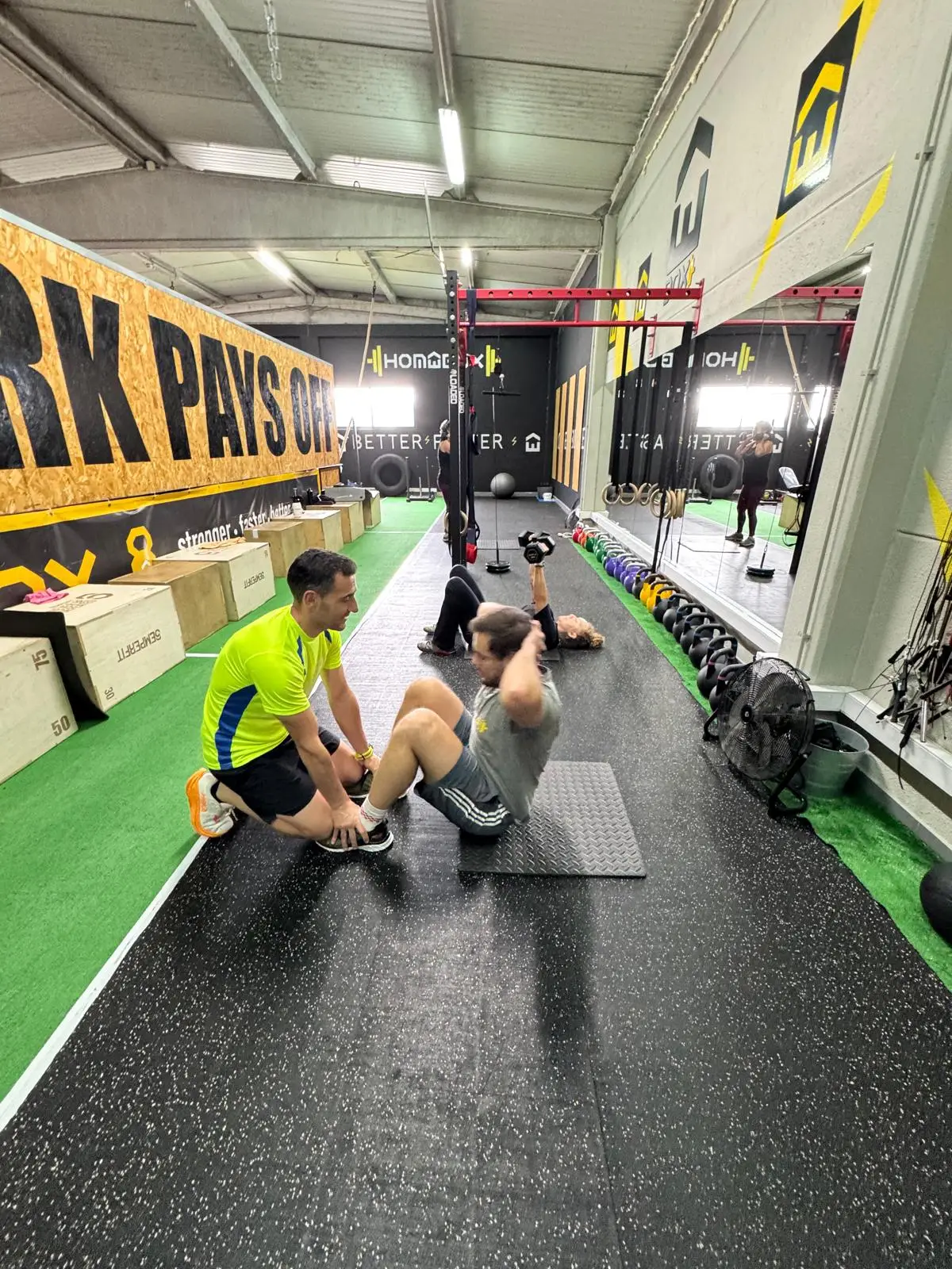 Coach a segurar os pés de um atleta durante um exercício de abdominais
